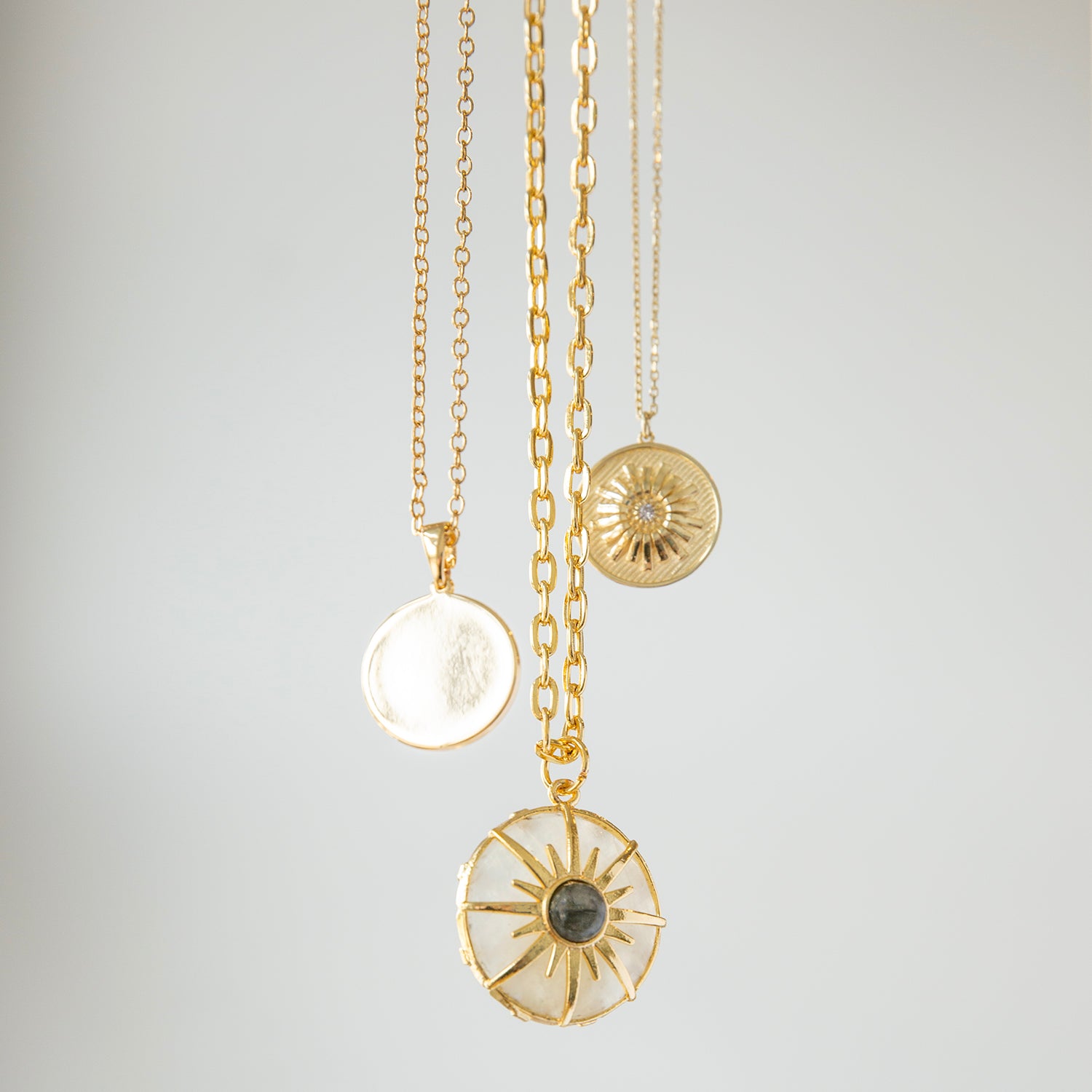 gold plated circle pendant with colored sunburst